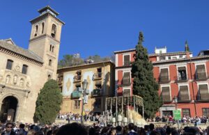 Virgen de la Esperanza en procesión por Santa Ana durante la Semana Santa en Granada con la torre de la Vela de la Alhambra al fondo